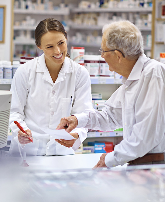 A pharmacist going over a prescription with a patient at the counter